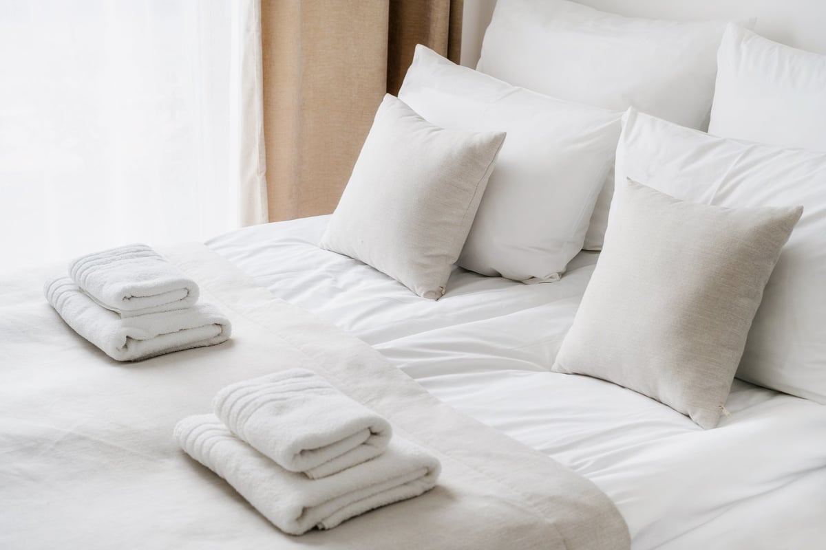 Fresh white bedclothes and towels in a hotel room